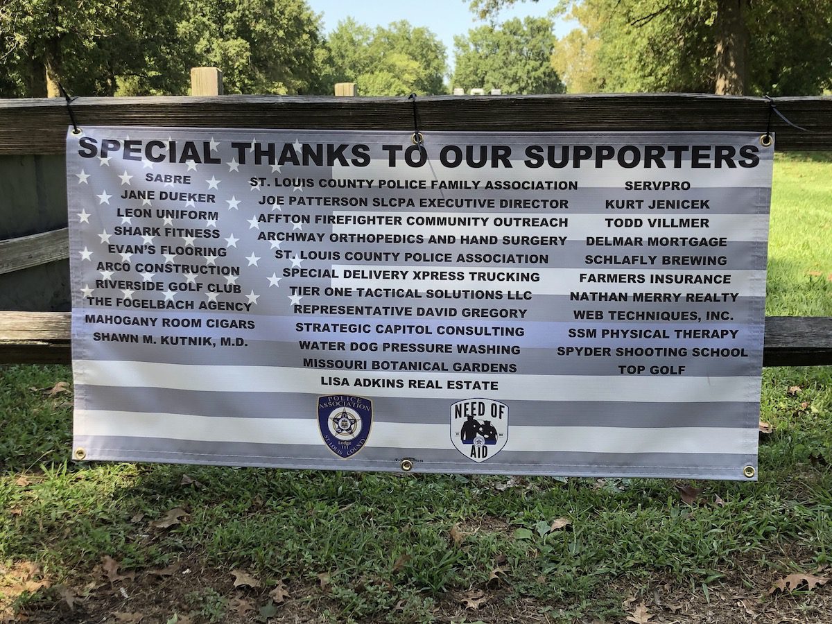 Banner listing supporters of a community event with names and organizations.