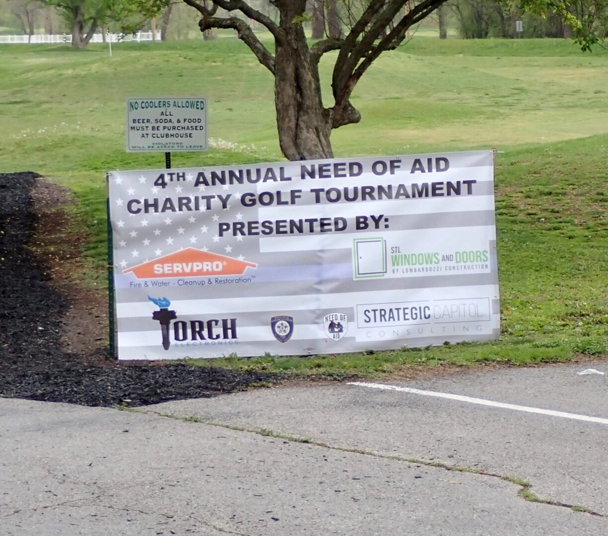 Banner for the 4th Annual Need of Aid Charity Golf Tournament outdoors.