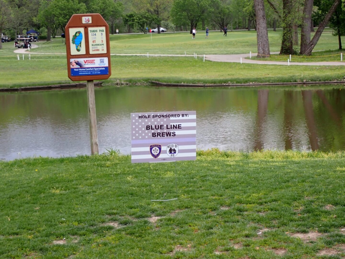 Golf course flooded with signs warning not to play on wet grass.