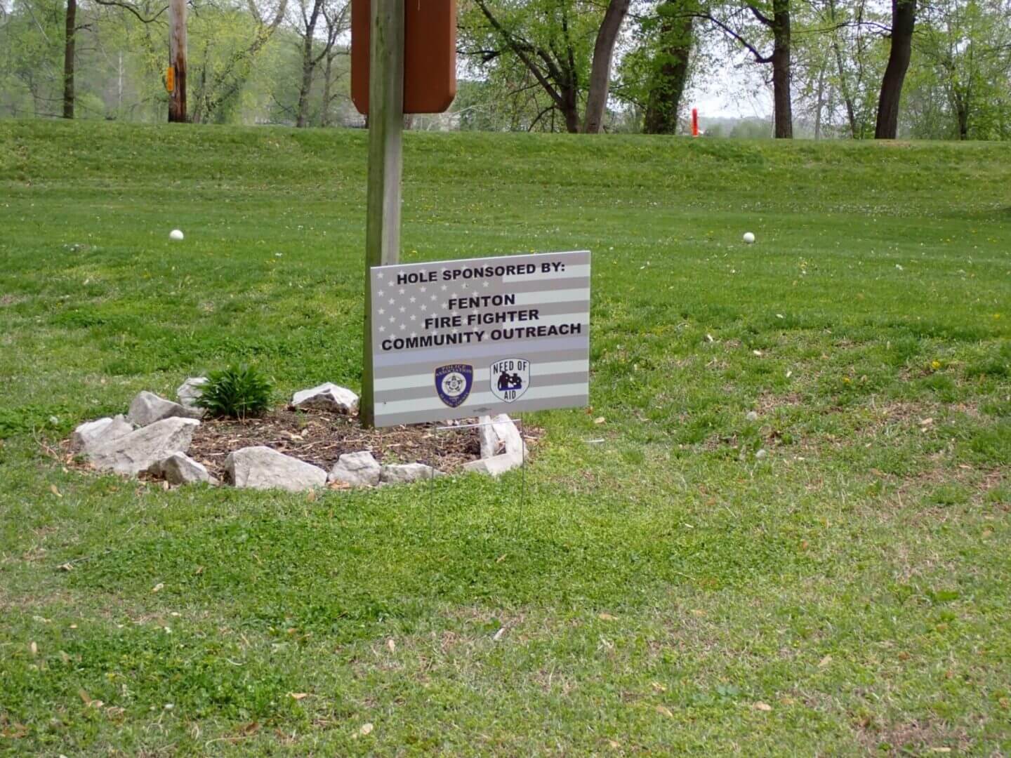 A sign in a park area instructs visitors to pick up dog waste.