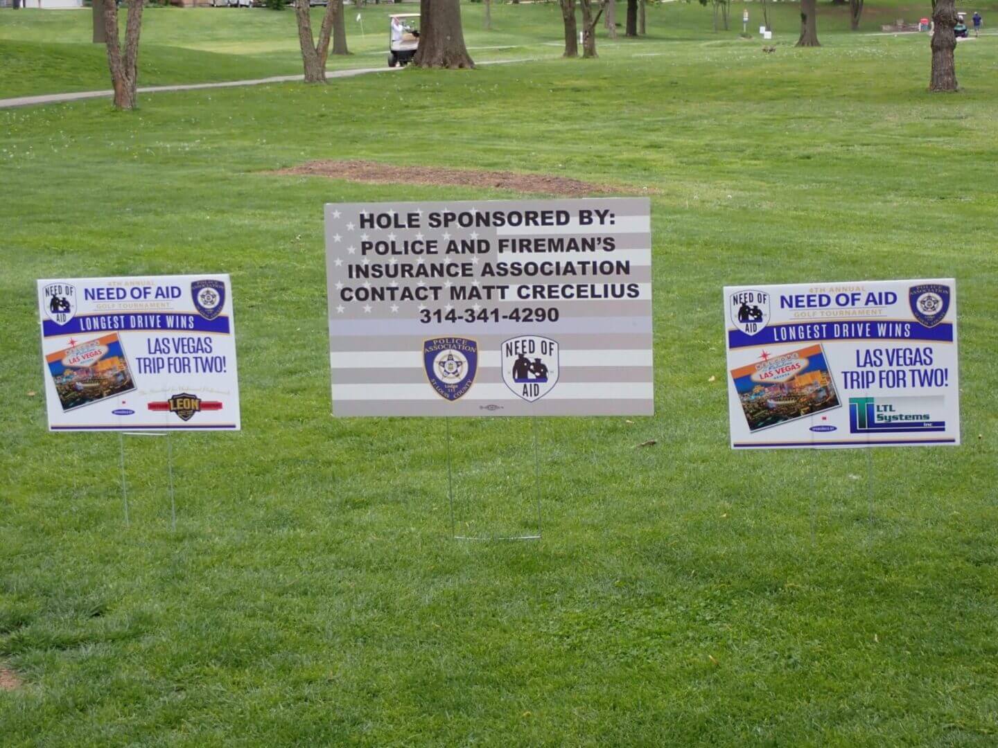 Signs on a grassy lawn warn of hazardous chemicals in the water.